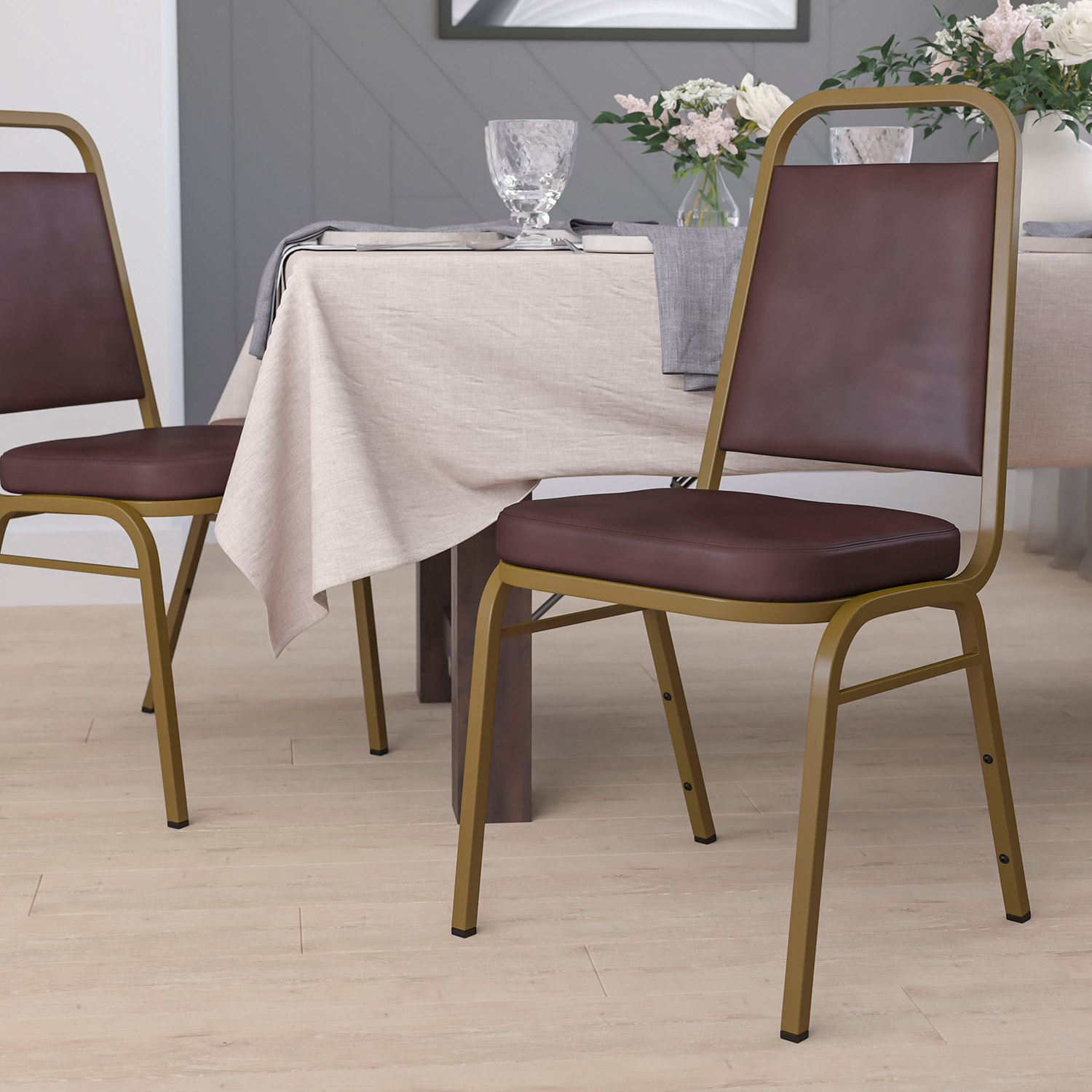 BLNK HERCULES Series Vinyl Trapezoidal Back Stacking Banquet Chair with Gold Frame